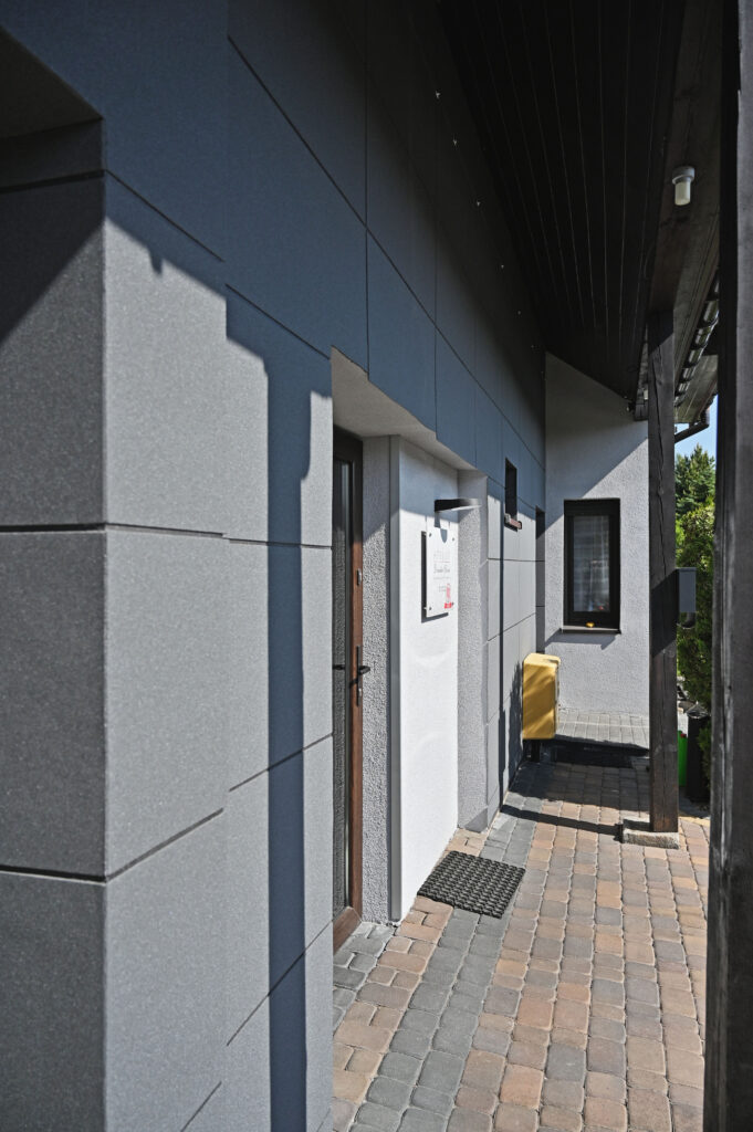 Gotowa elewacja lekka mokra z warstwą zbrojoną i zamontowanymi płytami kwarcowymi.