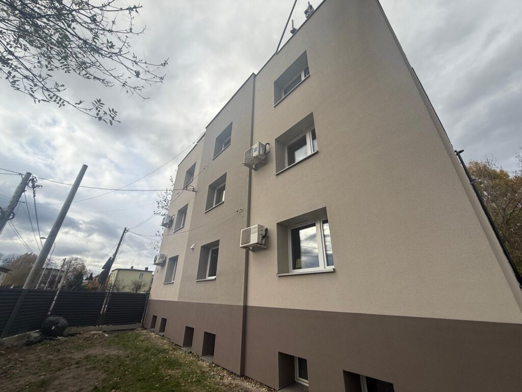 Elewacja budynku wielomieszkaniowego w Katowicach po nałożeniu tynku natryskowego i wykonaniu izolacji fundamentów.